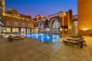 an indoor pool in a building with two lounges at The Cascades Golf Resort, Spa & Thalasso in Hurghada