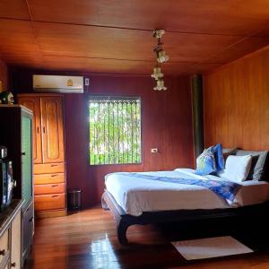 a bedroom with a bed and a window at Marin' s Home in Thalang