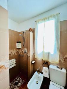 een badkamer met een toilet, een wastafel en een raam bij Cottage 3138 in Fucecchio