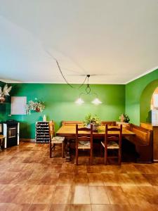 Cottage 3138 في فيوتشيتشيو: غرفة طعام مع طاولة خشبية وجدران خضراء