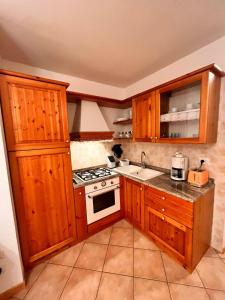 una cucina con armadi in legno e piano cottura. di Stella Alpina a Tarvisio