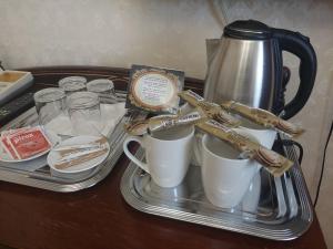 a tray with coffee mugs and a kettle on a table at Hotel Panorama in Mosonmagyaróvár