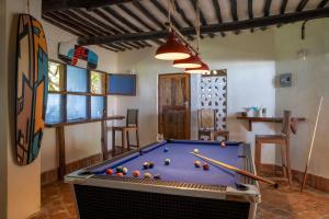 Una habitación con una mesa de billar con bolas encima. en Blue Marlin Beach Hotel, en Diani Beach