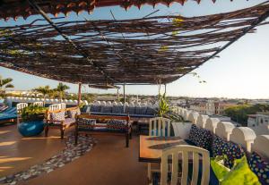 d'une terrasse sur le toit avec des chaises et des tables. dans l'établissement The Swahili House, à Zanzibar City