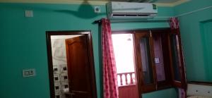 a room with a mirror and a window and a fan at S A HAVELI GUEST HOUSE in Bikaner