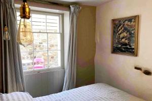a bedroom with a window and a bed in a room at Beachfront apartment with wood burner & courtyard in St. Leonards