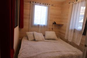 a bed in a wooden room with a window at Suite 1 - Le Rocher in Valloire