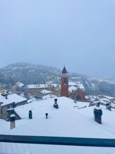 eine Stadt mit einem Uhrturm im Schnee in der Unterkunft Casa Belvedere Sant’Anna in Rivisondoli