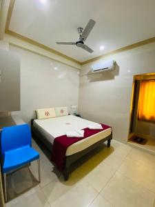 a bedroom with a bed and a blue chair at MARINA PALACE in Chennai