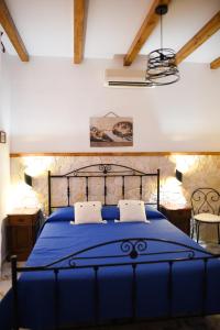 a blue bed with two pillows in a bedroom at B&B Antico Palmento in Lipari