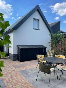 a patio with a table and chairs in front of a house at Bella Gelria in Wezep