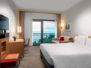 トラブゾンにあるノボテル トラブゾンの大きなベッドとバルコニーが備わるホテルルームです。