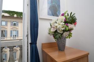 a vase of flowers sitting on a table next to a window at Olympia Hotel in Genoa