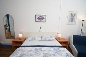 a bedroom with a bed and two lamps and a mirror at Olympia Hotel in Genoa