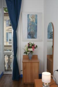 a living room with a vase of flowers on a table at Olympia Hotel in Genoa