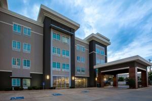 a large building with a parking lot in front of it at La Quinta Inn & Suites by Wyndham Durant in Durant