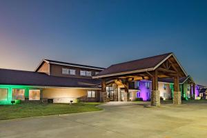 una casa grande con luces verdes y moradas en AmericInn by Wyndham Sayre, en Sayre