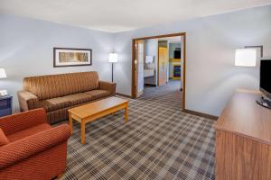 a living room with a couch and a table at AmericInn by Wyndham Sayre in Sayre