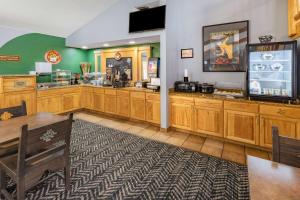 a fast food restaurant with wooden cabinets and a tv at AmericInn by Wyndham Sayre in Sayre