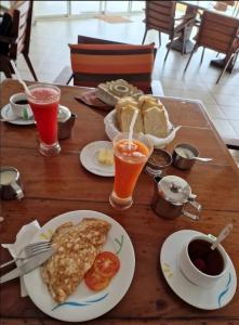 una mesa de madera cubierta con platos de comida y bebida en Villa 47 Akurala en Andurangoda