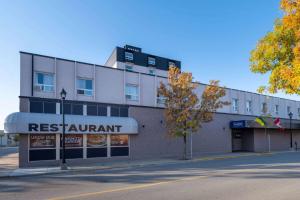 a building with a restaurant on the side of a street at Travelodge by Wyndham Prince Albert in Prince Albert