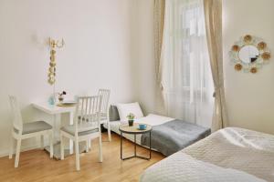 een slaapkamer met een bed en een tafel met een stoel bij Elegant Studio in New Town by Prague Days in Praag