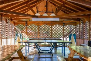 a ping pong table in a pavilion with wooden ceilings at Motel Long Lake and Cottages in Long Lake