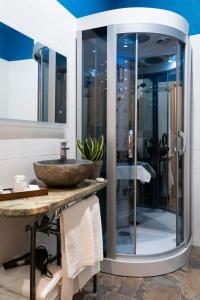 瓦雷澤的住宿－Varese Suites，一间带水槽和玻璃淋浴的浴室
