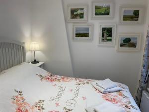 a bedroom with a bed with towels and pictures on the wall at Carr’s cottage Eyam Peak District, in Eyam
