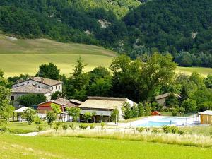 a house and a pool in a field with a mountain at Lush holiday home in Urbania with bubble bath in Urbania