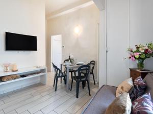 ein Wohnzimmer mit einem Tisch, Stühlen und einem TV in der Unterkunft Stunning Apartment in the Heart of Florence in Florenz