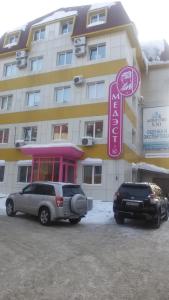dos coches estacionados frente a un hotel en Valencia Mini Hotel, en Khabarovsk