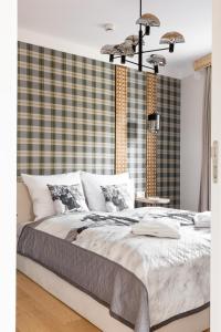 a bedroom with a large bed with a plaid wall at Villa Monte Zakopane in Zakopane