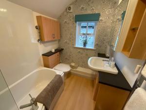 ein Badezimmer mit Badewanne, Toilette und Waschbecken in der Unterkunft Carr’s cottage Eyam Peak District, in Eyam + 43 Fotos