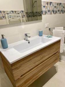 łazienka z białą umywalką i lustrem w obiekcie Chalaroste home w mieście Terrasini
