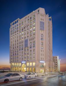 een groot gebouw met auto's geparkeerd voor het bij Central Inn Souq Waqif in Doha