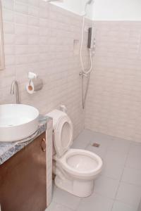 uma casa de banho com um WC e um lavatório em JJS Hotel and Resort em San Remigio