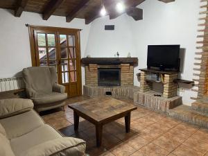 a living room with a tv and a fireplace at Casa Rural MAITETXU in Viscarret-Guerendiáin