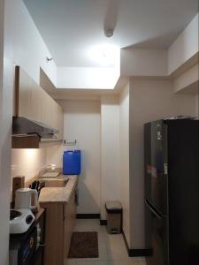 La cuisine est équipée d'un réfrigérateur noir et d'un évier. dans l'établissement Celandine by DMCI - JM staycation, à Manille