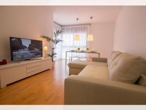 a living room with a couch and a flat screen tv at Apartamento céntrico y acogedor en Sitges in Sitges