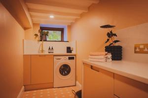 a laundry room with a washer and dryer at River Cottage, a luxurious and cosy riverside cottage for two in Welshpool
