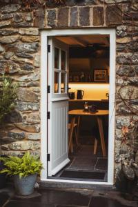 a door leading into a room with a table at River Cottage, a luxurious and cosy riverside cottage for two in Welshpool