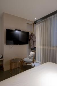 1 dormitorio con 1 cama, TV y silla en Hound Hotel Seomyeon-Beomcheon en Busan