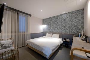 1 dormitorio con cama, escritorio y ventana en Hound Hotel Seomyeon-Beomcheon en Busan