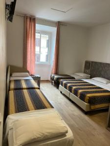 um quarto com três camas e uma janela em Hotel principe em Roma