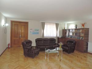 sala de estar con 2 sillas de cuero y mesa en Guest House "Old House" en Tʼelavi