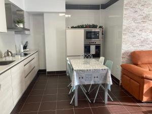 een kleine keuken met een tafel en een bank bij HyP - La Casa de Noa in Arcade