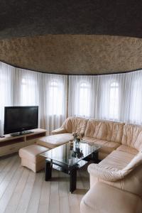 uma sala de estar com um sofá e uma televisão em Knyazhyi Dvir em Sokilʼnyky