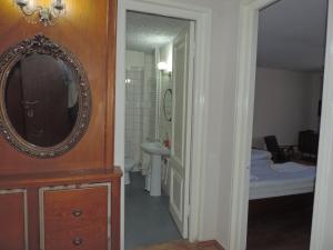 Habitación con baño con espejo y lavabo. en Guest House "Old House" en Tʼelavi