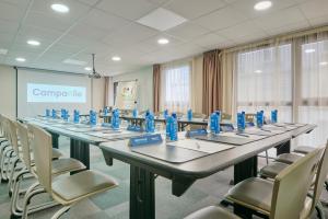 Una habitación con mesas y sillas con botellas azules. en Campanile Lyon Centre - Berges du Rhône en Lyon